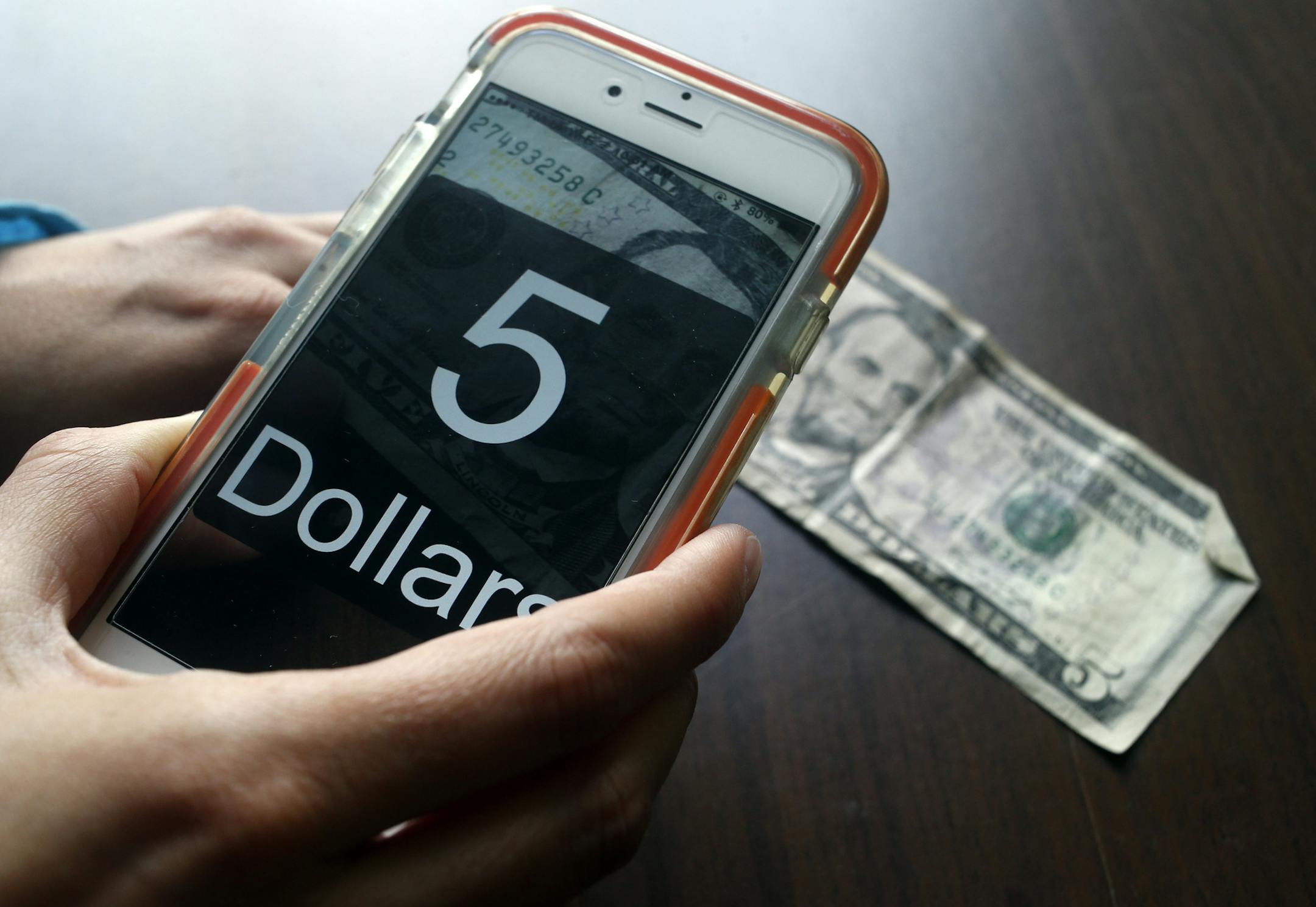 Erin Lauridsen, blind since birth, uses the MoneyReader app to identify currency.