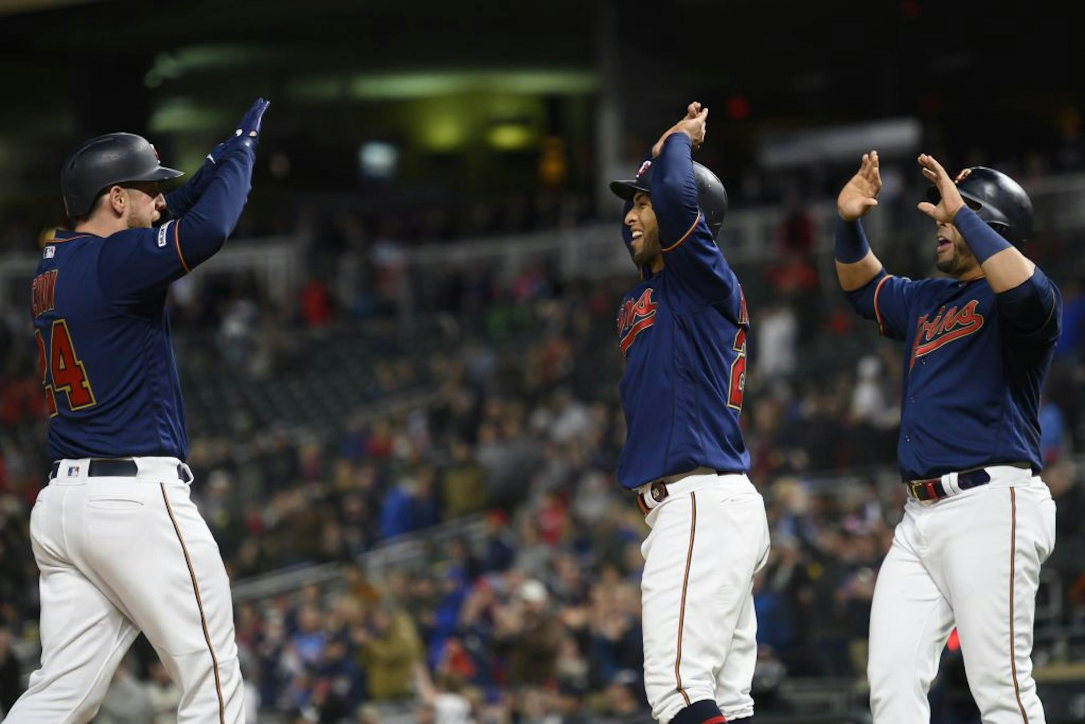 From left, Minnesota Twins first baseman C.J. Cron (24), left fielder Eddie Rosario (20) and designated hitter Nelson Cruz (23) celebrated a three run home run hit by Cron in the bottom of the fifth inning against the Detroit Tigers.
