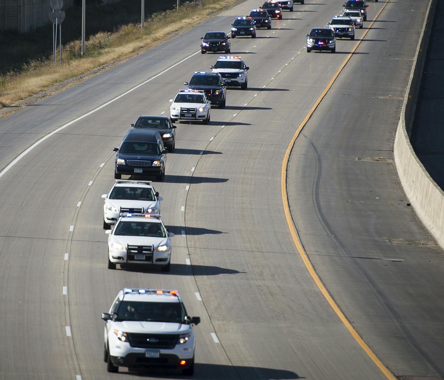 A parade of police vehicles drove east down the I-94 while escorting a hearse carrying the body of a fallen sheriff's deputy killed by an inmate they were guarding early Sunday morning in St. Cloud Hospital. ] (AARON LAVINSKY/STAR TRIBUNE) aaron.lavinsky@startribune.com parade of police vehicles escorting body of slain deputy to Ramsey Co med examiner - left st cloud appr 1:40 pm - catch them before 94 splits into 694 /494 at Maple Grove