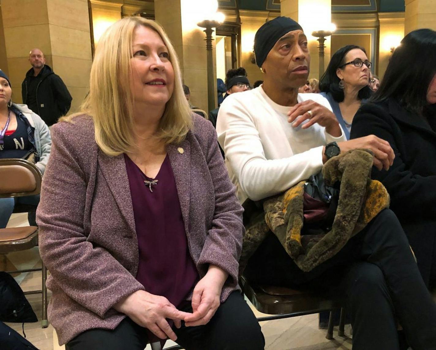 Minnesota state Sen. Chris Eaton, left, and Chazz Smith, right, a cousin of the late rock star Prince, attend a rally at the Minnesota state Capitol in St. Paul, Minn., Wednesday, Jan. 30, 2019, in support of legislation to fight the opioid crisis. Prince died in 2016 of an accidental opioid overdose. Eaton is sponsoring a bill to force drug companies to pay more of the costs of the crisis. Smith told the crowd Prince's death shows the power that addiction can hold on anyone.