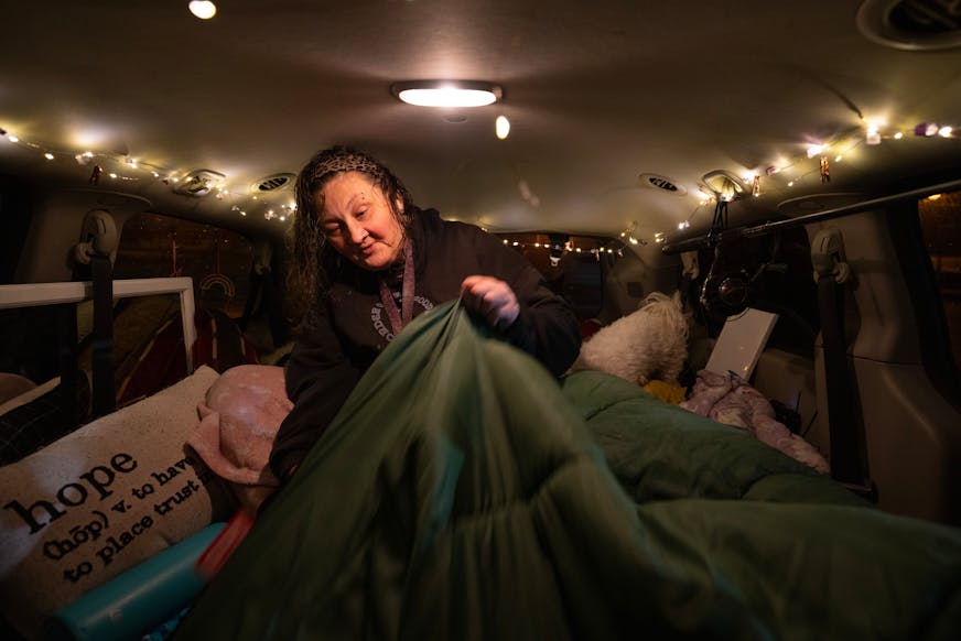 Fresh from the shower, Lynette Ruse got her bedding sorted out before going to sleep in her van Monday night, October 30, 2023 in Duluth. At night, the parking lot of the Damiano Center becomes Safe Bay, a place where unhoused people can sleep in their vehicles without fear for their safety. A mobile hygiene trailer has showers and bathrooms for people to use before they settle in for the night. Safe Bay is an initiative of Stepping On Up, a  coalition of Duluth social service organizations, many of which are housed in the Damiano Center.   ]   JEFF WHEELER • Jeff.Wheeler@startribune.com