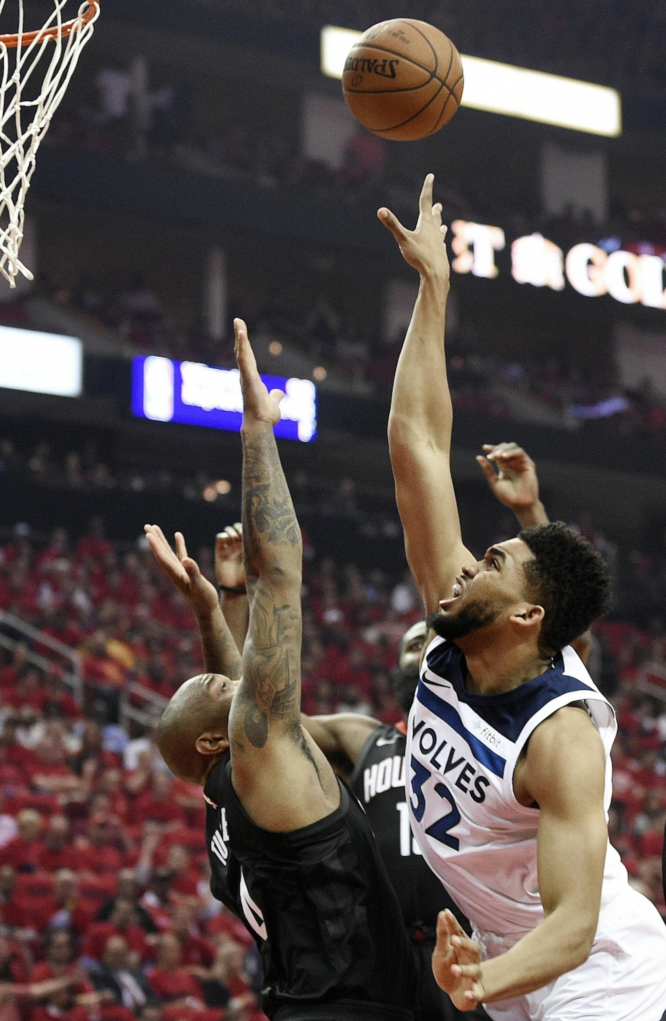 Minnesota Timberwolves center Karl-Anthony Towns, right, shoots over Houston Rockets forward PJ Tucker during the first half in Game 5 of a first-round NBA basketball playoff series, Wednesday, April 25, 2018, in Houston.