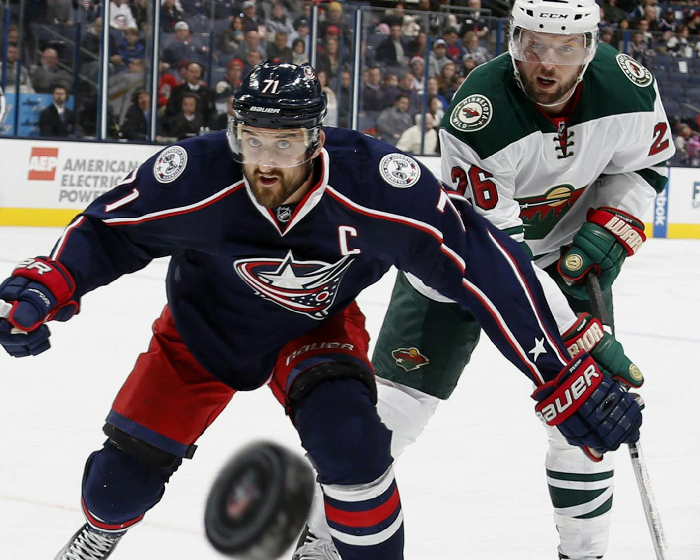 The Columbus Blue Jackets' Nick Foligno (71) and the Minnesota Wild's Thomas Vanek (26) chase the puck in the first period at Nationwide Arena in Columbus, Ohio, on Tuesday, Jan. 5, 2016. (Brooke LaValley/Columbus Dispatch/TNS)