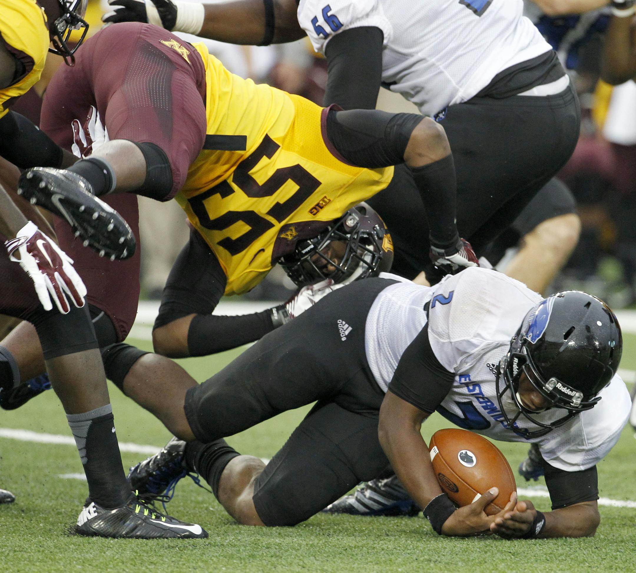 Eastern Illinois quarterback Jalen Whitlow, lands under Minnesota defensive lineman Theiren Cockran (55) after carrying the ball for a nine and 1/2-yard gain during the second quarter of an NCAA college football game in Minneapolis Thursday, Aug. 28, 2014. (AP Photo/Ann Heisenfelt) ORG XMIT: MNAH104