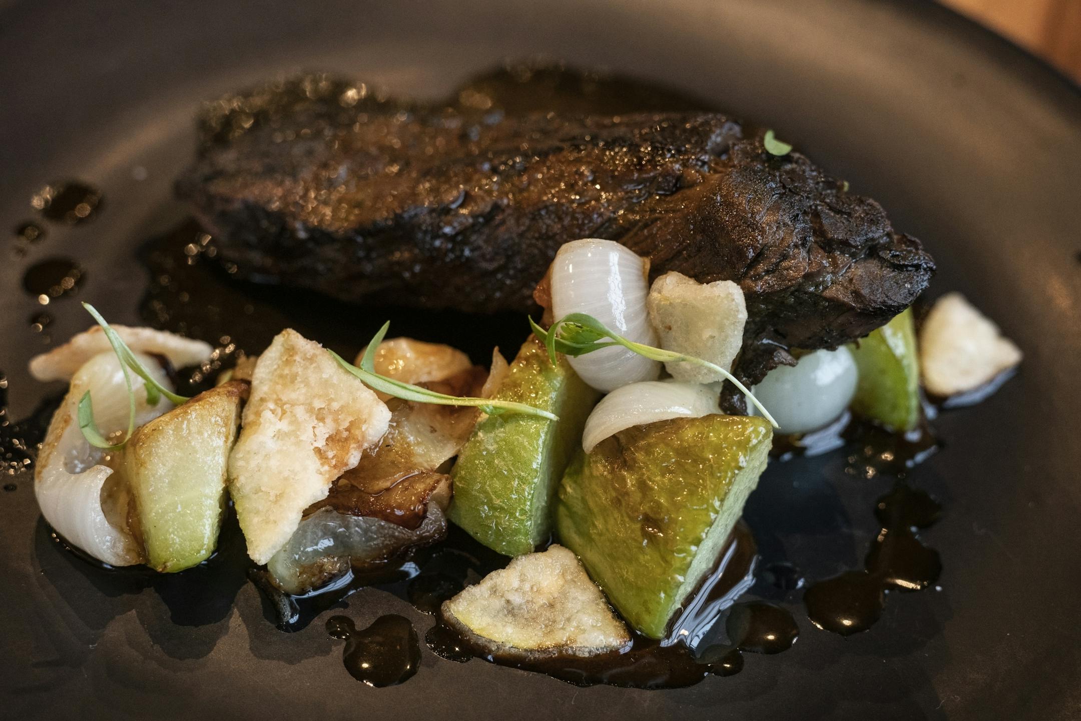 The carne aside has a griller hanger steak, chayote, jugo de chile pasilla.