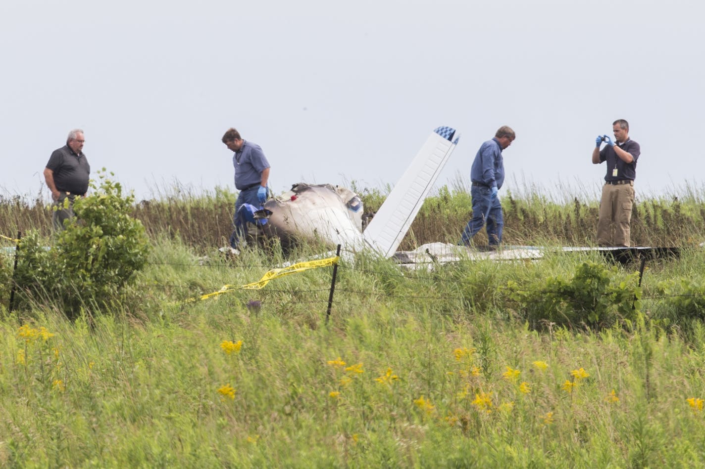 Officials investigate the site of a fatal plane crash in Alden Township, southwest of Amery, Wis. on Tuesday, July 28, 2015.