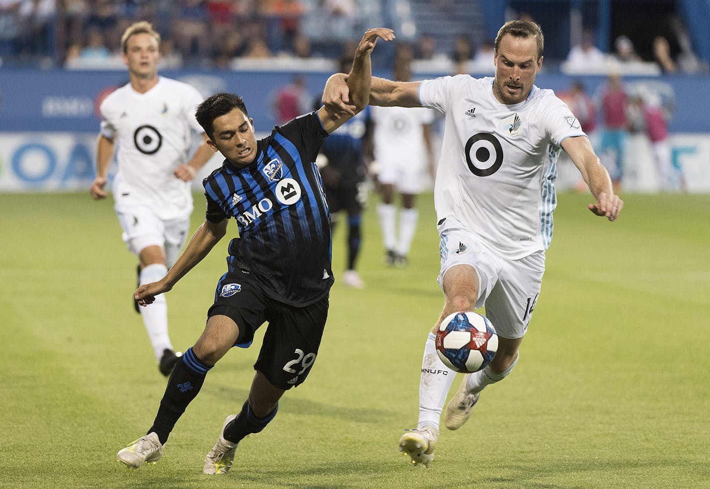 Montreal Impact's Mathieu Choiniere, left, and Minnesota United's Brent Kallman vie for the ball during the second half of an MLS soccer match Saturday, July 6, 2019, in Montreal. (Graham Hughes/The Canadian Press via AP)