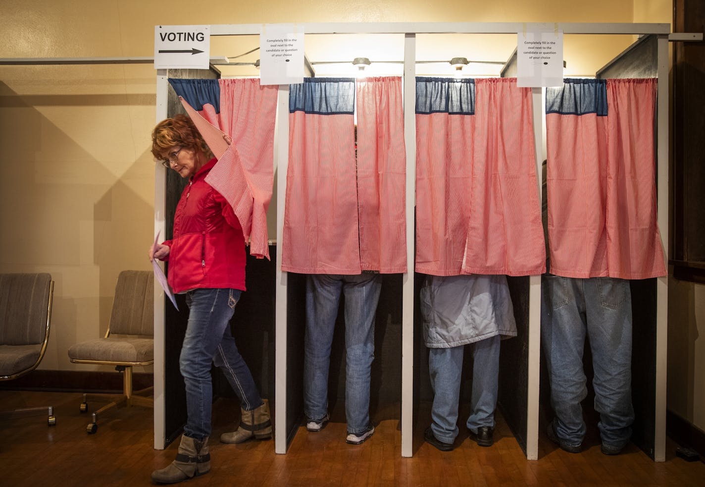 Christine Giroux exits the voting booth at Transit Town Hall. The curtains, an ode the American flag, were sewn by a past election official.