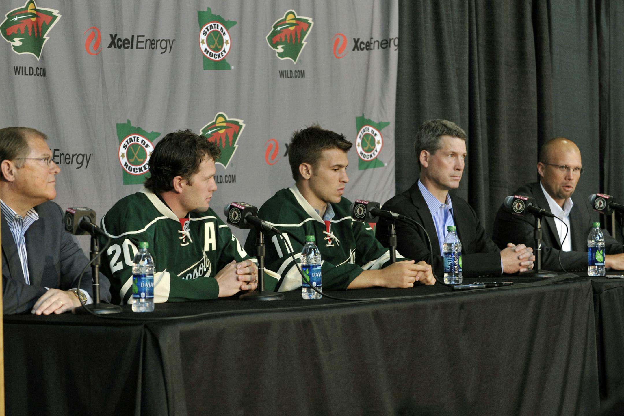 Minnesota Wild NHL hockey head coach Mike Yeo, right, addresses reporters as general manager Chuck Fletcher, second from right, and team owner Craig Leipold, left, listen during a news conference introducing new players Ryan Suter, second left, and Zach Parise on Monday, July 9, 2012 in St. Paul, Minn. The two signed 13-year contracts with the Wild for $98 million. (AP Photo/Jim Mone) ORG XMIT: MNJM105