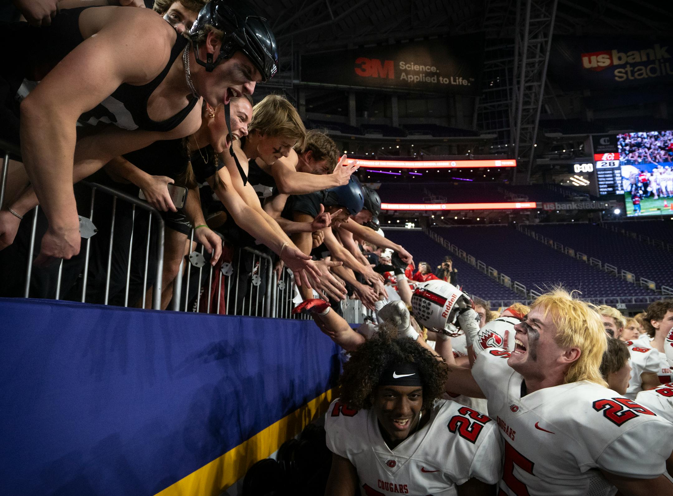 Centennial High School students congratulate their classmates after the team cinched a 28-27 win against Edina High School at the 6a Championship game at U.S. Bank Stadium for the Prep Bowl XLI in Minneapolis on Friday, Nov. 24, 2023. ] Angelina Katsanis • angelina.katsanis@startribune.com