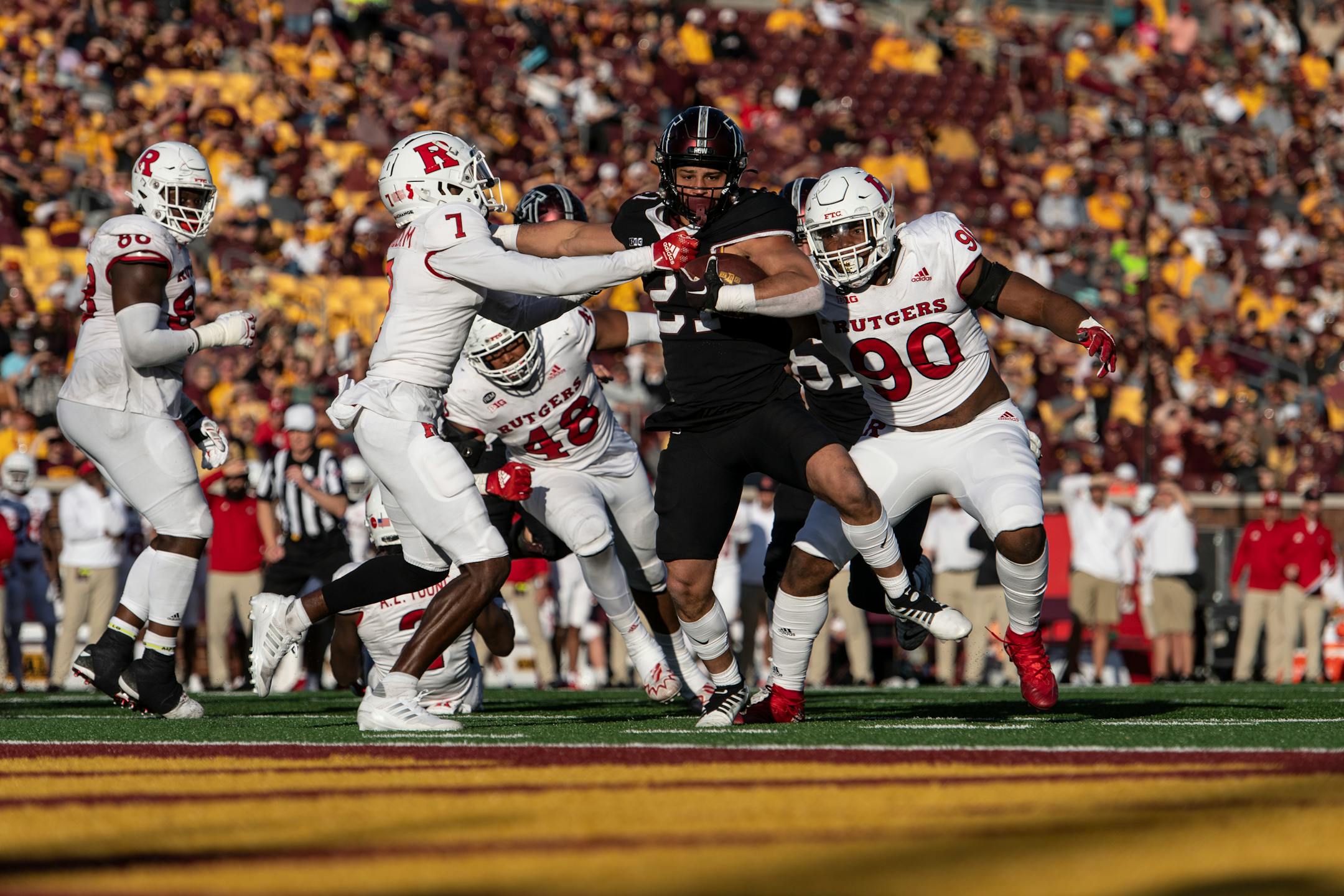 Minnesota Golden Gophers running back Bryce Williams (21) broke a tackle by Rutgers Scarlet Knights defensive back Robert Longerbeam (7) for a touchdown, but the play was reversed due to an offensive holding call in the fourth quarter.