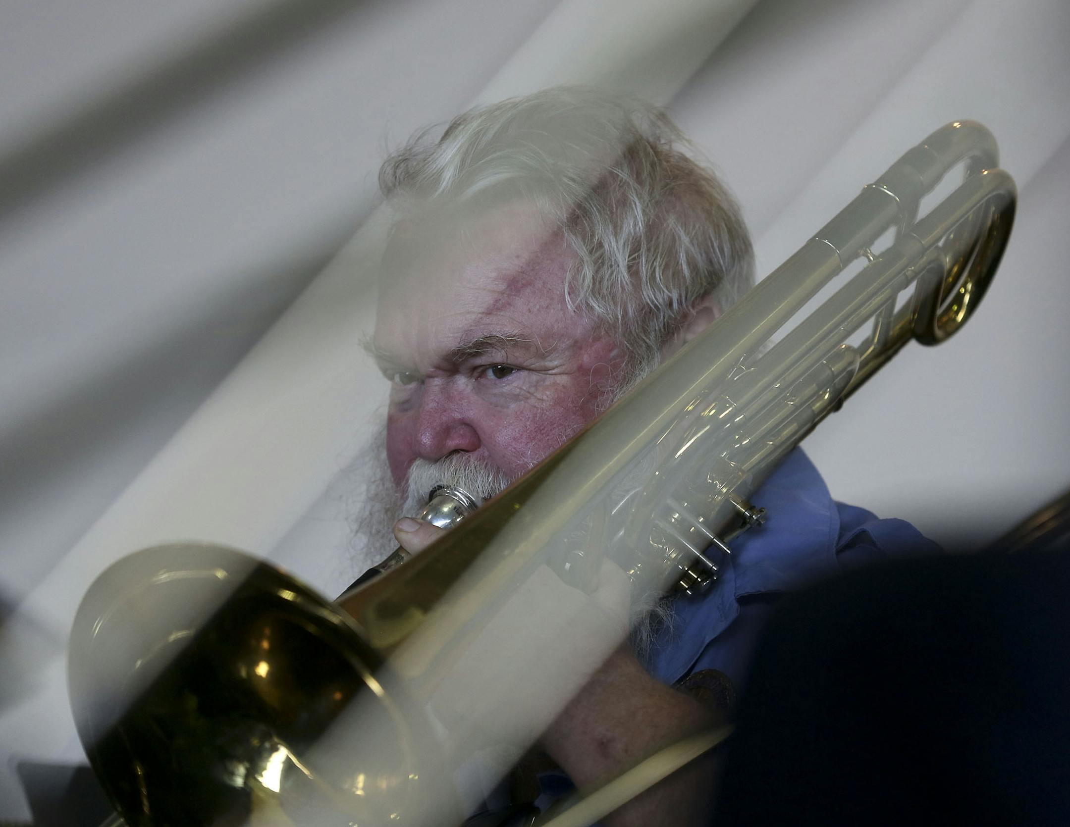 With trombone slides shading his face Cliff Rude played his trombone during the St. Paul Police Band concert at the Como Park Pavilion in St. Paul Min., Tuesday, August 6, 2013. ] (KYNDELL HARKNESS/STAR TRIBUNE) kyndell.harkness@startribune.com