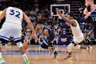 Memphis guard Ja Morant handles the ball between Timberwolves forward Treveon Graham, right, and center Karl-Anthony Towns