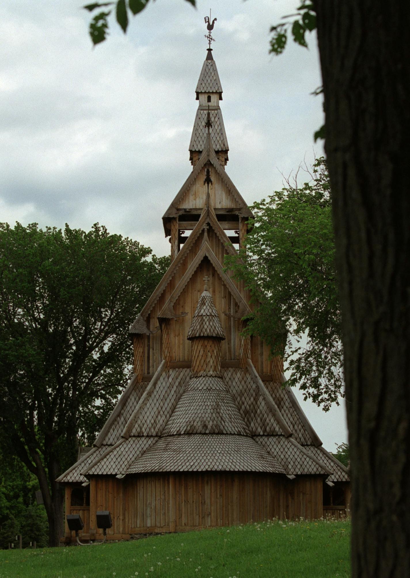 GENERAL INFORMATION: MOORHEAD, MN. 5/30/2001: Guy Paulson's retirement project was a tad more ambitious than most. He's spent the past five years building a full-size replica of a 13th century Norwegian stave church. Had most of it done the first year, in fact. That included the big stuff - the exterior with it's the 72-foot spire and roofs covered with 24,000 hand-cut cedar shingles. The interior, with it's 18 massive 27-foot tall staves (vertical posts) each decoratively handcarved by Paulson,