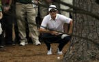 Justin Rose, of England, examines his shot in the rough off the seventh fairway during the fourth round of the Masters golf tournament Sunday, April 1