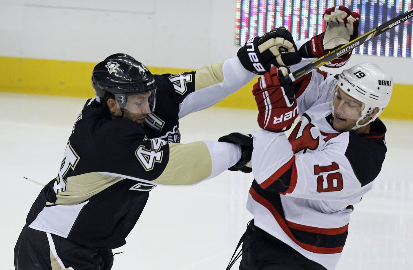 Pittsburgh Penguins' Brooks Orpik (44) checks New Jersey Devils' Travis Zajac (19) off the puck in the first period of an NHL hockey game in Pittsburgh on Thursday, Oct. 3, 2013. The Penguins won 3-0. (AP Photo/Gene J. Puskar) ORG XMIT: MIN2013110816131672