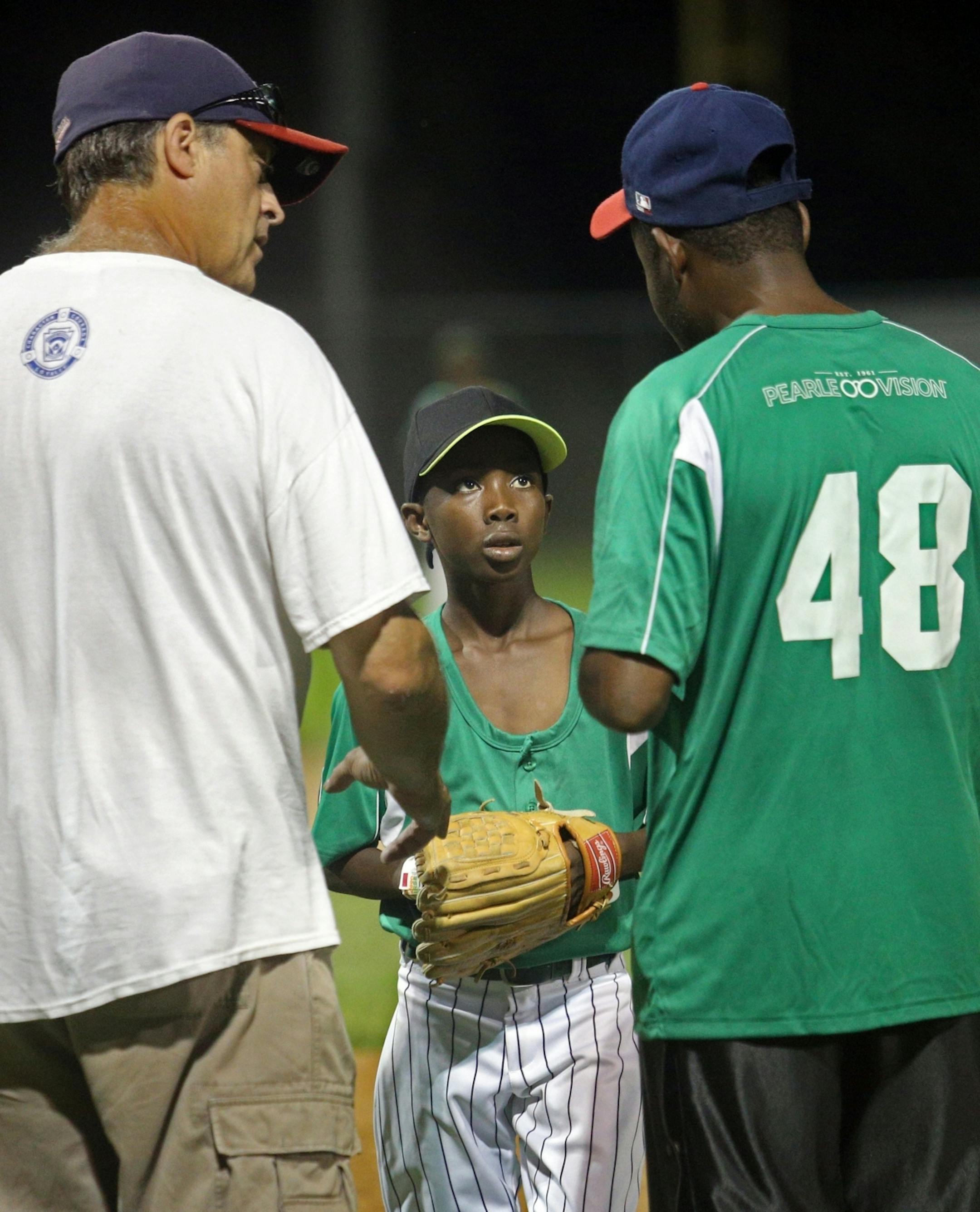 Carlos Agoua, center receives instruction from coach Fernando Atannon, right, in French after Atannon receives instructions from Wally Langfellow, left, in English.