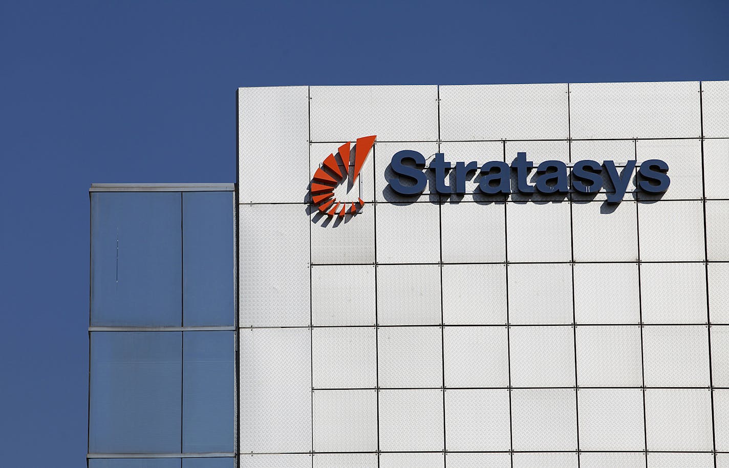 A logo sits on display outside the offices of Stratasys Ltd., manufacturer of 3D printing machines, in Rehovot, Israel, on Sunday, July 28, 2013. Stratasys Ltd., a New York-listed maker of printers that create three-dimensional objects, plans acquisitions to expand into devices that use metals. Photographer: Ariel Jerozolimski/Bloomberg