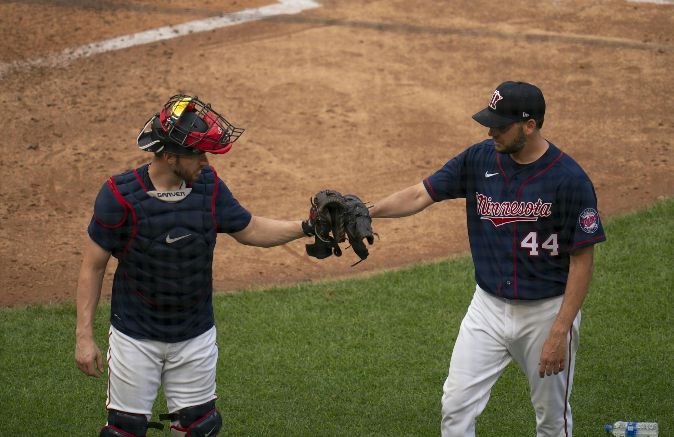 Minnesota Twins pitcher Rich Hill (44) touched gloves with catcher Mitch Garver (8) after throwing live batting practice Monday evening.