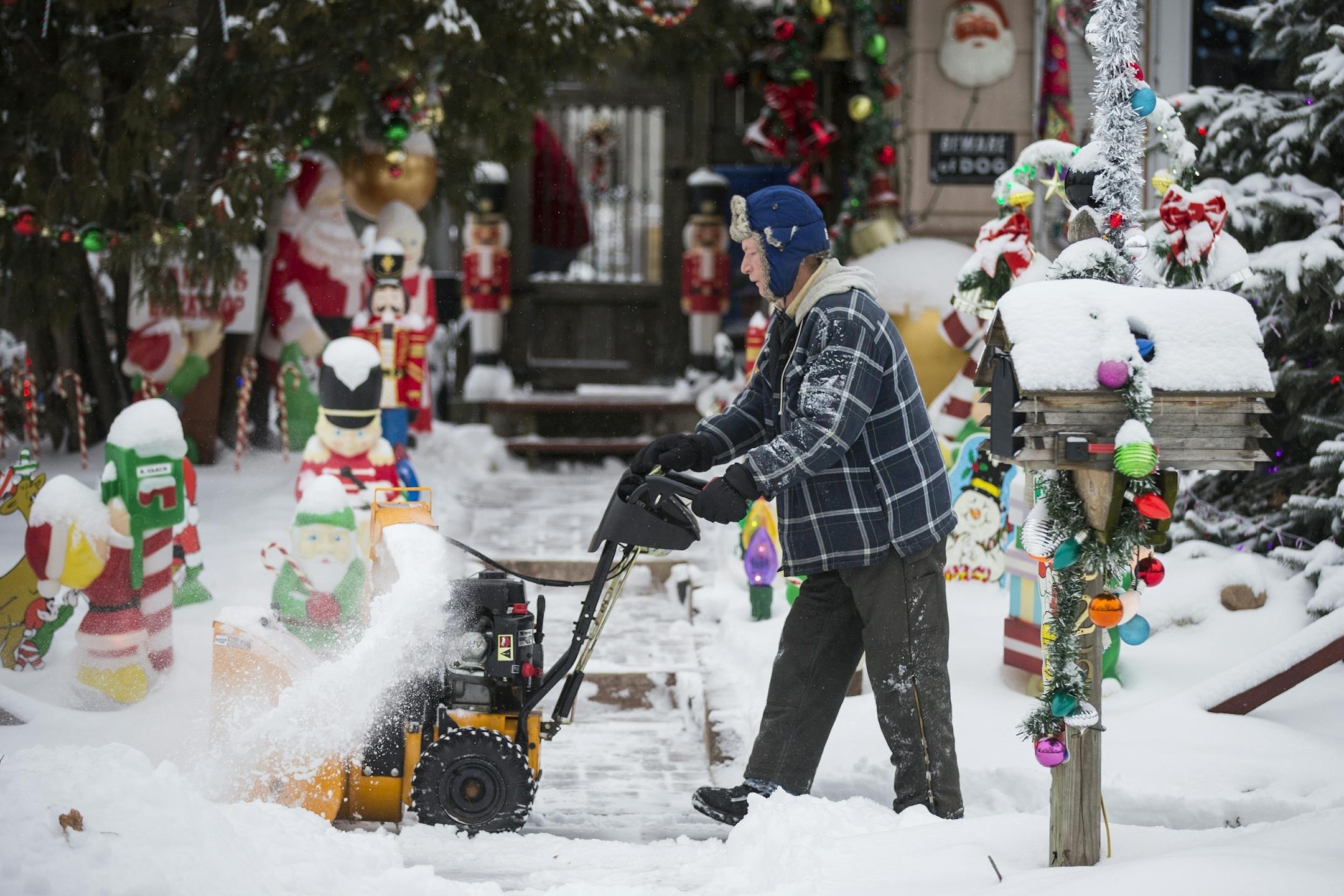 Chris Bowker clears his sidewalk of snow in St. Paul on Tuesday, December 29, 2015. "It's good to see the white stuff," said Bowker.