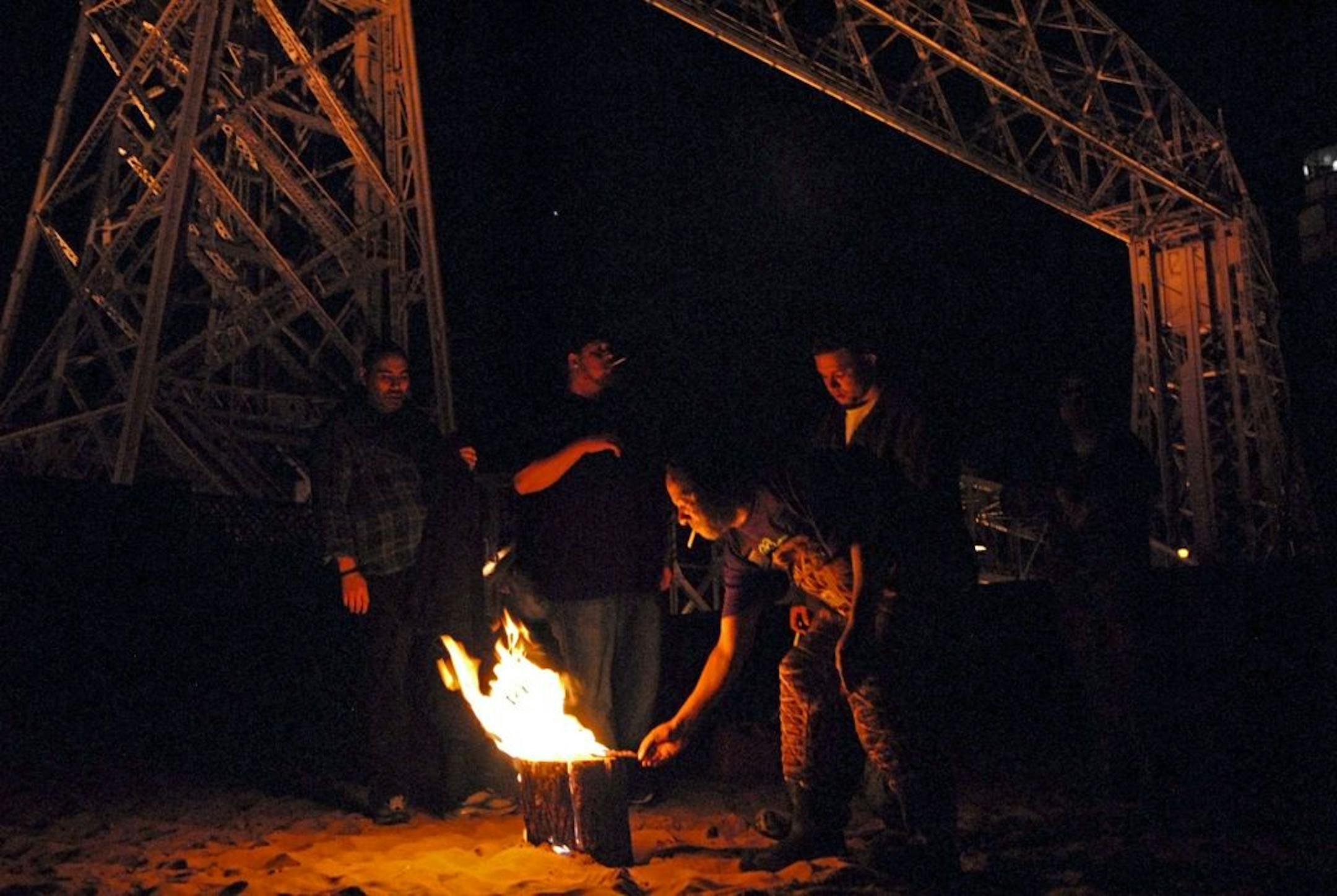 With Duluth's Aerial Lift Bridge in the background, a group of smelters and others who had come to watch smelters gathered around a "Swedish Handwarmer,'' a log that had been lacerated with a chain saw and stuffed with steel wool to burn slowly from the inside out.