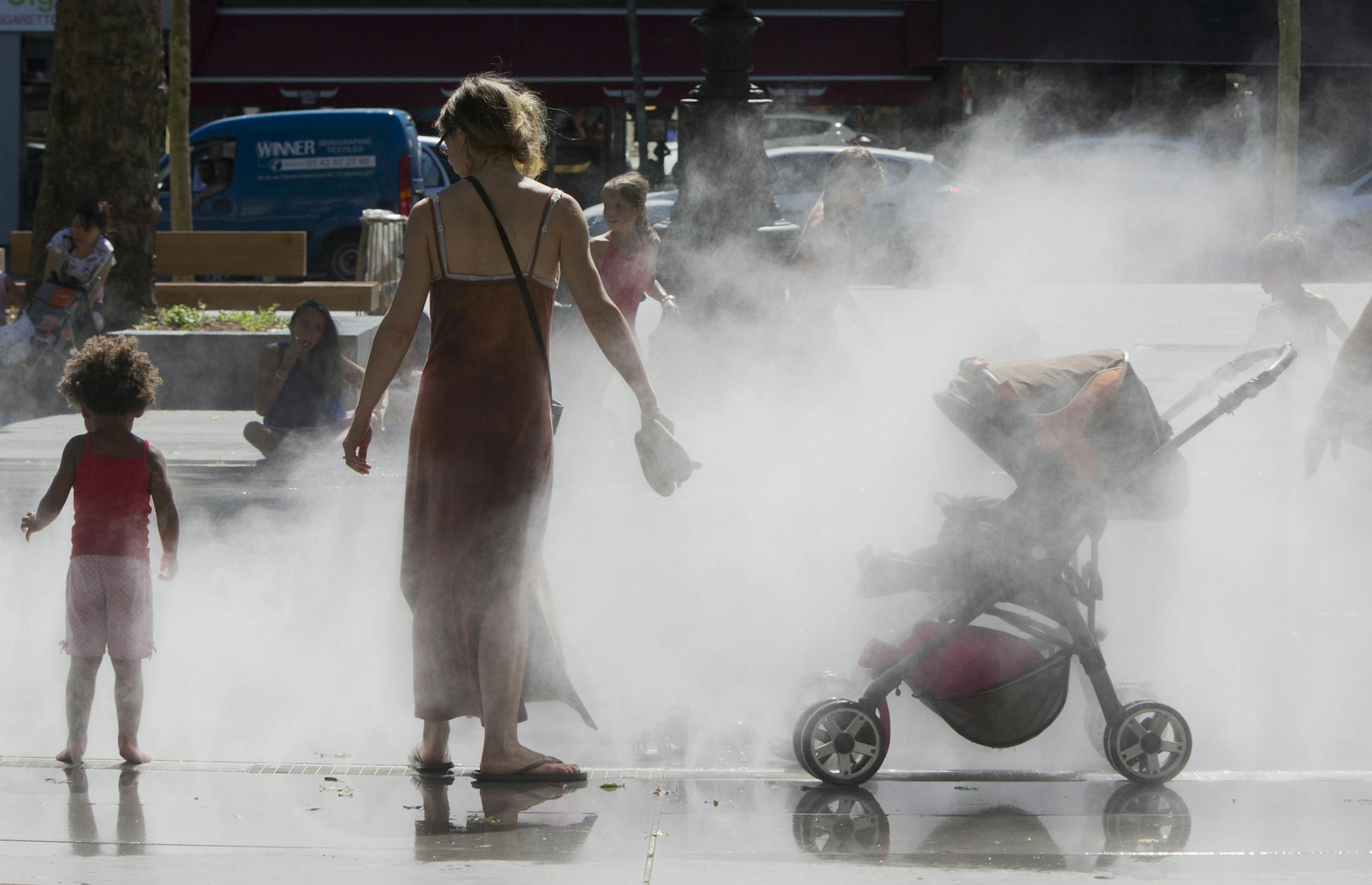 People cool down under jets of water in Paris. Thursday, Aug. 1, 2013. Temperatures Paris reached 37 degrees Celsius (98 Fahrenheit) (AP Photo/Jacques Brinon)