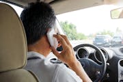 Some Minnesota legislators want to make it illegal for drivers like this man to use hand-held devices like cellphones while driving.