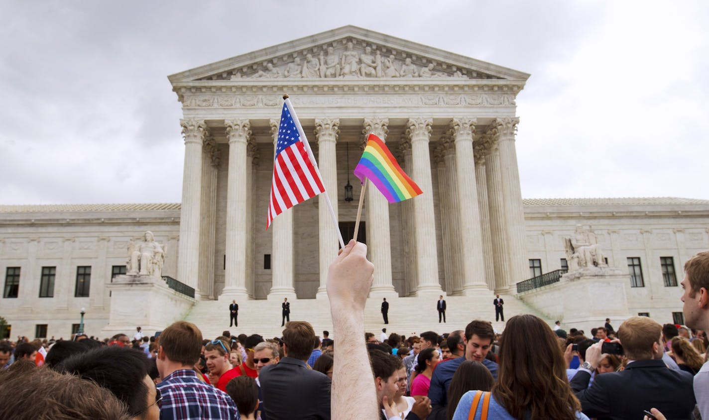 FILE - In this June 26, 2015, file photo, a crowd celebrates outside of the Supreme Court in Washington after the court declared that same-sex couples have a right to marry anywhere in the U.S. On Friday, Aug. 16, 2019, the Justice Department brief filed telling the Supreme Court that federal law allows firing workers for being transgender. The brief is related to a group of three cases that the high court will hear in its upcoming term related to LGBTQ discrimination in the workplace. (AP Photo