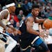 Minnesota Timberwolves guard Jimmy Butler, right, drives the lane past Denver Nuggets guard Torrey Craig in the first half of an NBA basketball game W