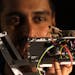 Lead author Vivek Nityananda holds a praying mantis atop a mantis-inspired robot arm. (Newcastle University, England) ORG XMIT: 1223330