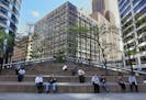 Folks settle in for lunch break on the large steps outside the Canadian Pacific building in downtown Minneapolis