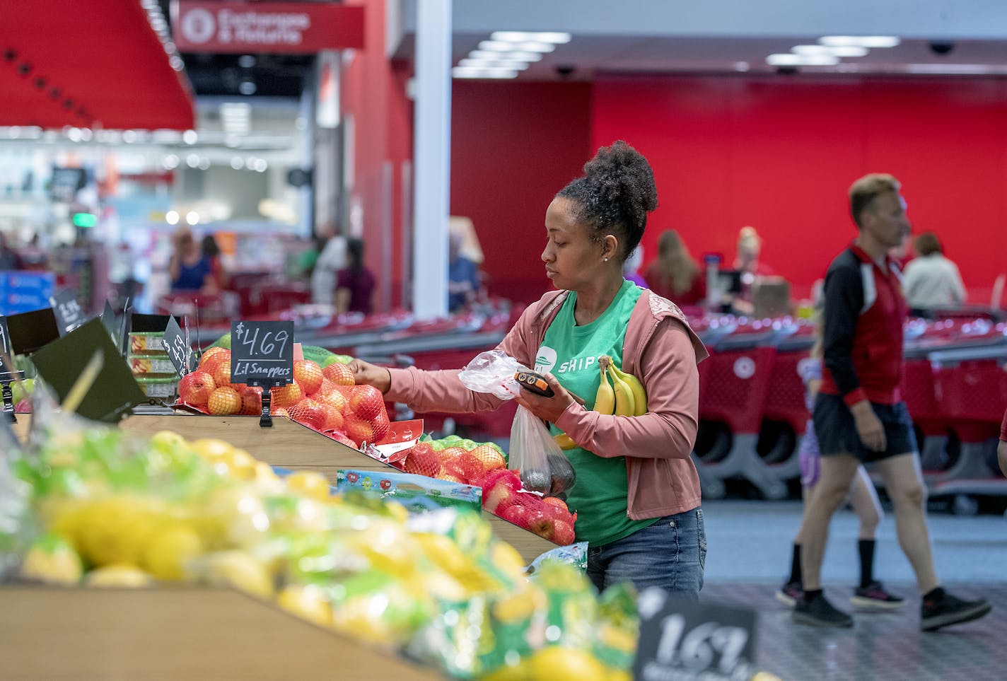 Shipt will offer bonuses to people who work over the Thanksgiving weekend. Shown is a Shipt worker shopping at Target now offers a servithe Edina Target.