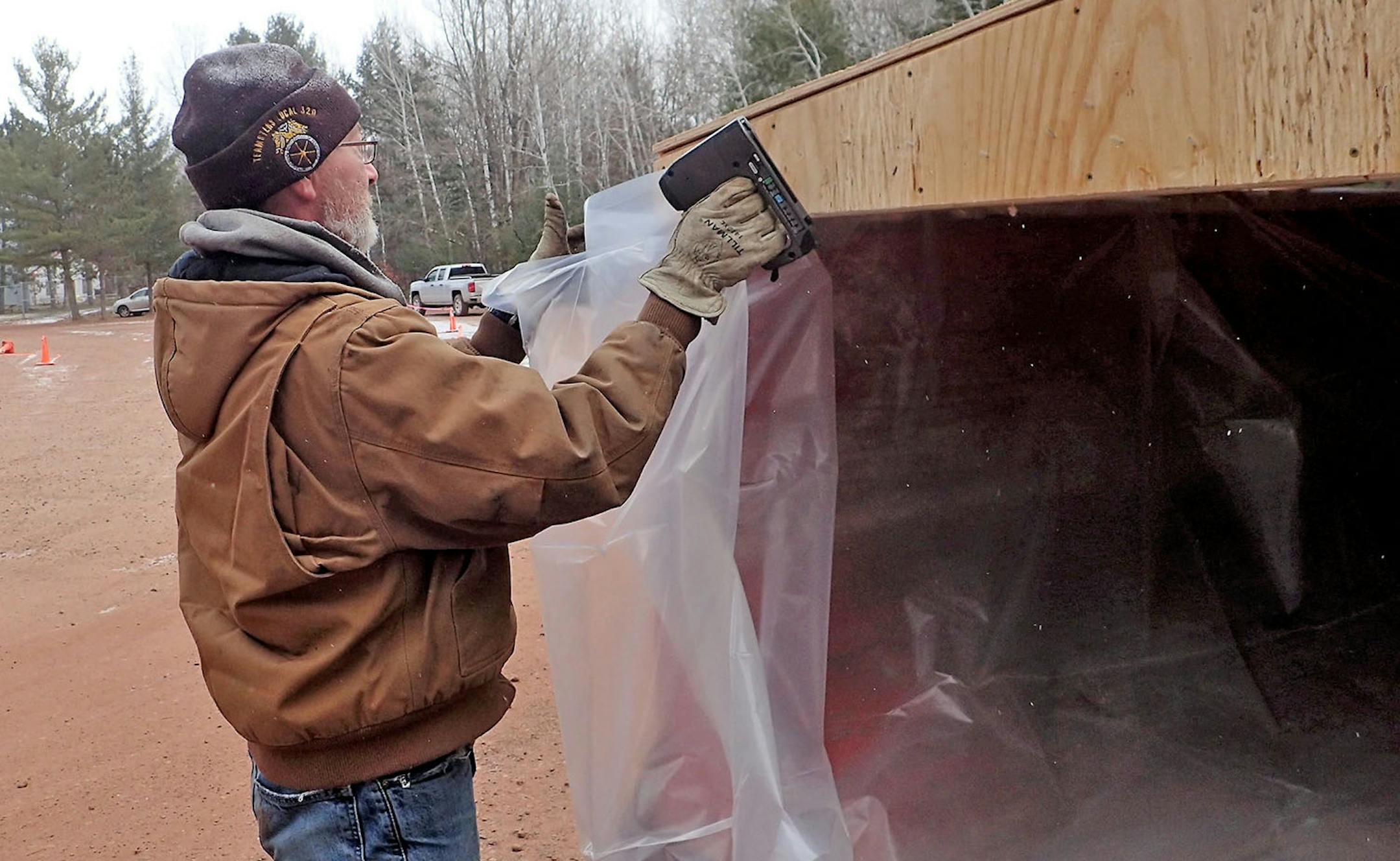 Shawn Denman, working under a DNR contract to supply rolloff dumpsters at six check stations in CWD Management Zone 604, installs a plastic liner on a dumpster he dropped last week at the station in Crosby. The dumpsters are available to hunters who chose to quarter their deer and safely discard the carcass to prevent the possible spread of CWD. DNR staffers at these stations tag deer and remove lymph nodes from them as part of the agency's mandatory testing requirement this year.