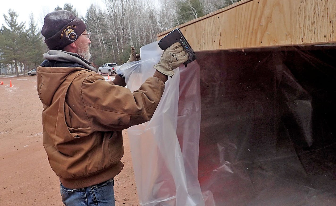 Shawn Denman, working under a DNR contract to supply rolloff dumpsters at six check stations in CWD Management Zone 604, installs a plastic liner on a dumpster he dropped last week at the station in Crosby. The dumpsters are available to hunters who chose to quarter their deer and safely discard the carcass to prevent the possible spread of CWD. DNR staffers at these stations tag deer and remove lymph nodes from them as part of the agency's mandatory testing requirement this year.