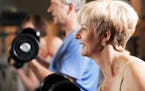 Three senior people - two women and one man - in the gym lifting dumbbells, exercising. istock