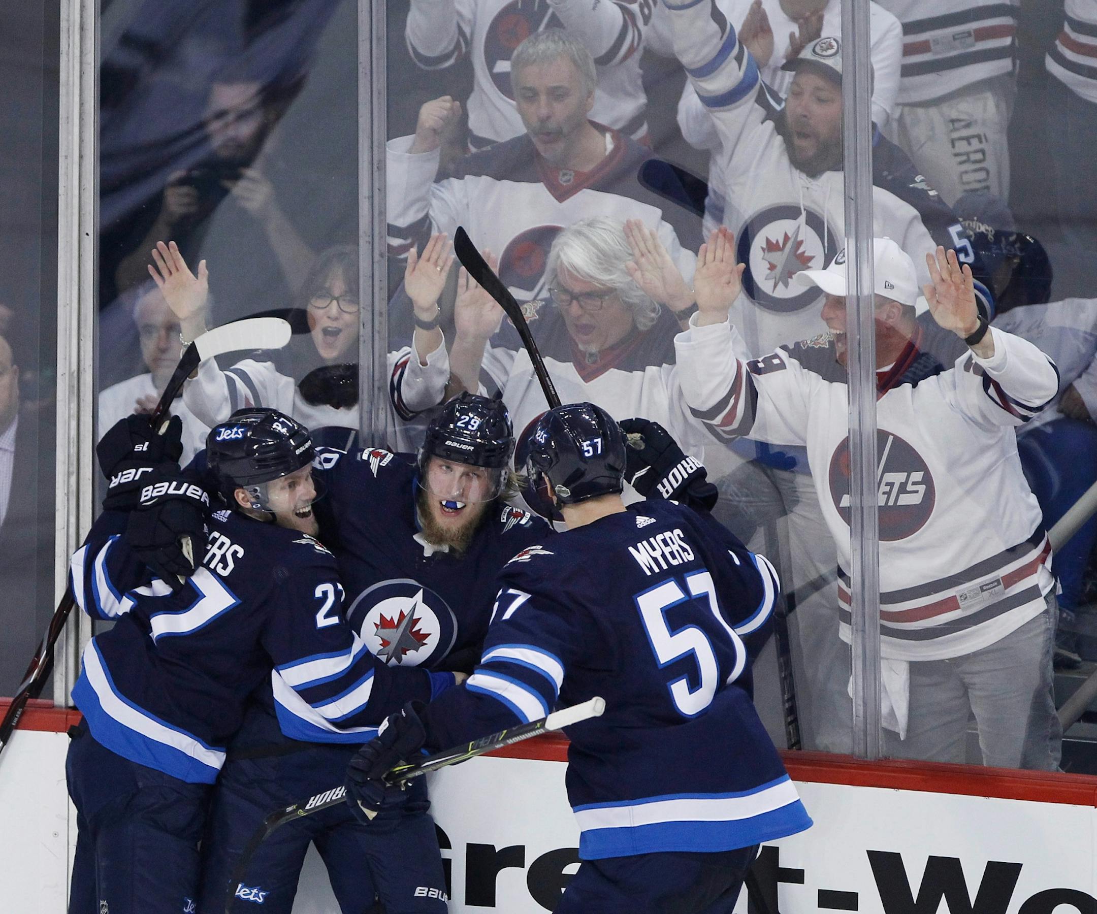 Winnipeg Jets' Nikolaj Ehlers (27), Patrik Laine (29) and Tyler Myers (57) celebrate Laine's goal against the Minnesota Wild during the third period of Game 1 in an NHL hockey first-round playoff series Wednesday, April 11, 2018, in Winnipeg, Manitoba.