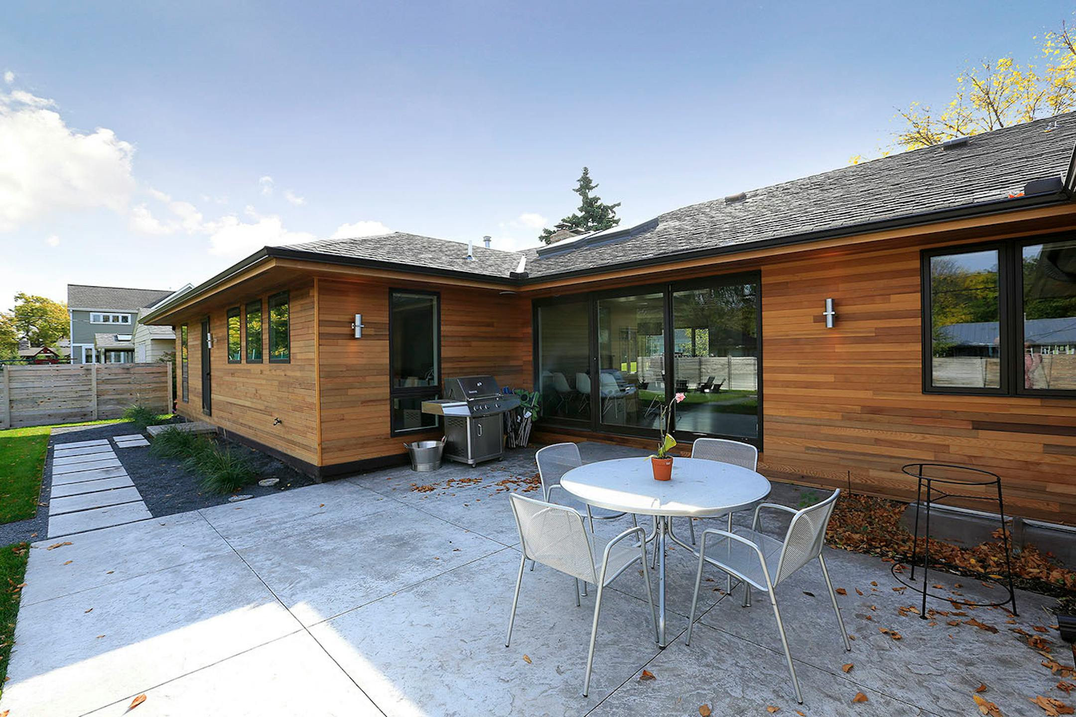 Another backyard view of the cedar-sided home with the patio.