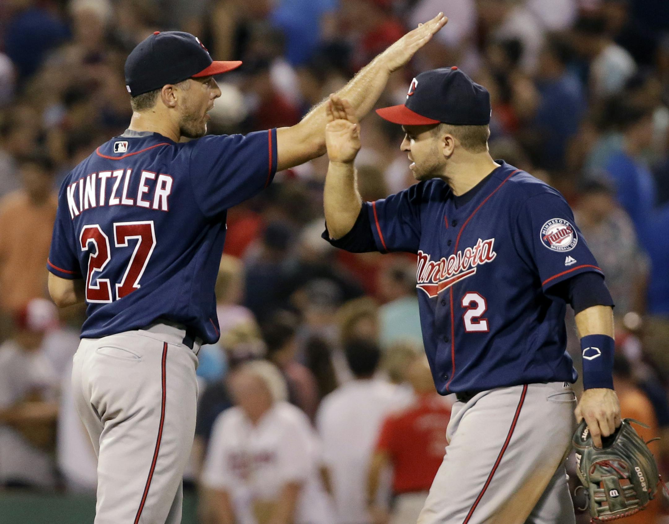 Minnesota Twins relief pitcher Brandon Kintzler (27) and second baseman Brian Dozier (2) celebrate after the Twins defeated the Boston Red Sox 2-1 in a baseball game at Fenway Park, Friday, July 22, 2016, in Boston. (AP Photo/Elise Amendola)