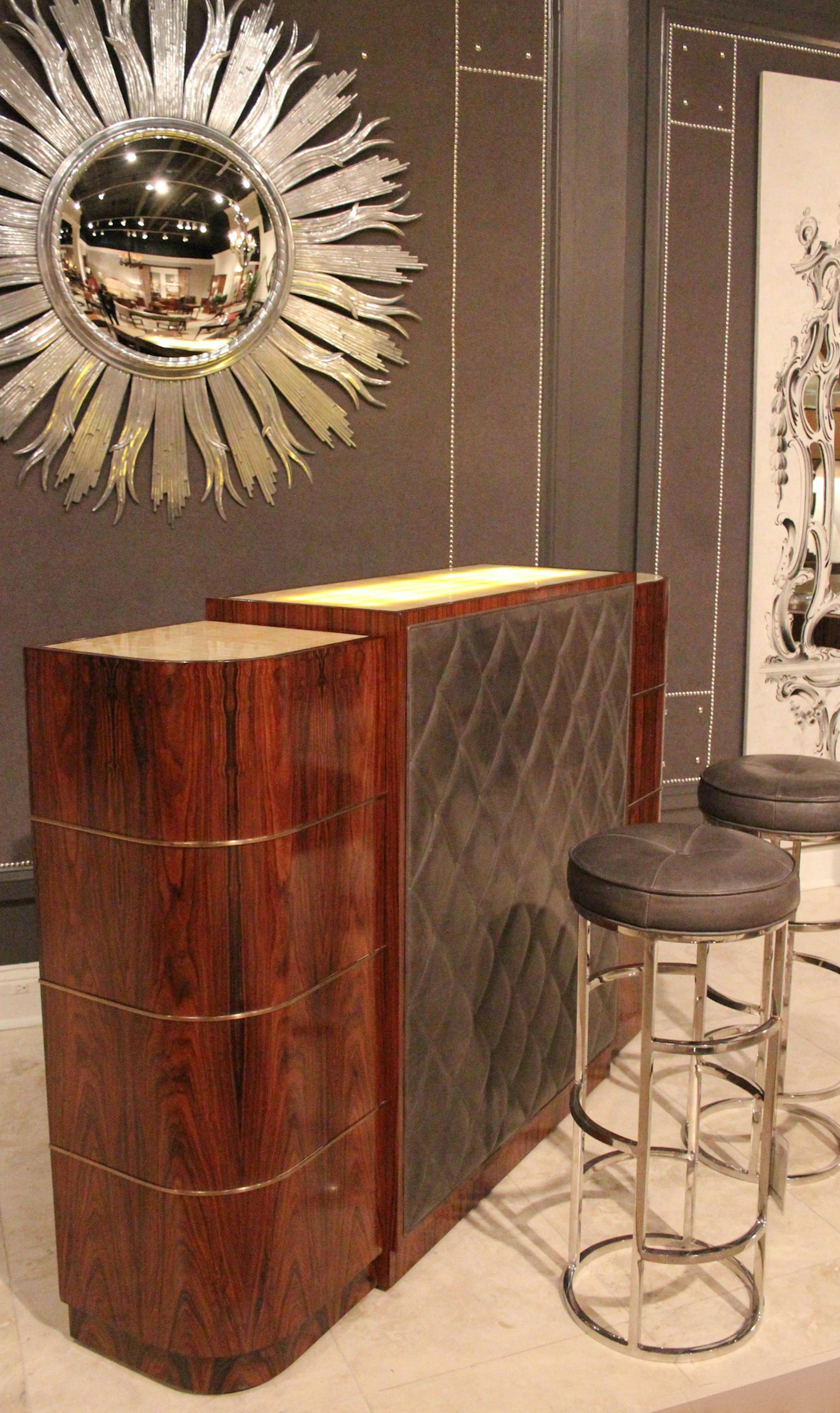 SH13G037HOMEBARS July 8, 2013 -- Wild rosewood veneered and padded leather bar with horizontal brass molding details by Theodore Alexander. The rectangular top center section has a backlit onyx panel. Inspired by an Art Deco original. The stainless-steel stools have leather padded seats. (SHNS photo by Patricia Sheridan/Pittsburgh Post-Gazette) (Newscom TagID: shnsphotos147086.jpg) [Photo via Newscom]
