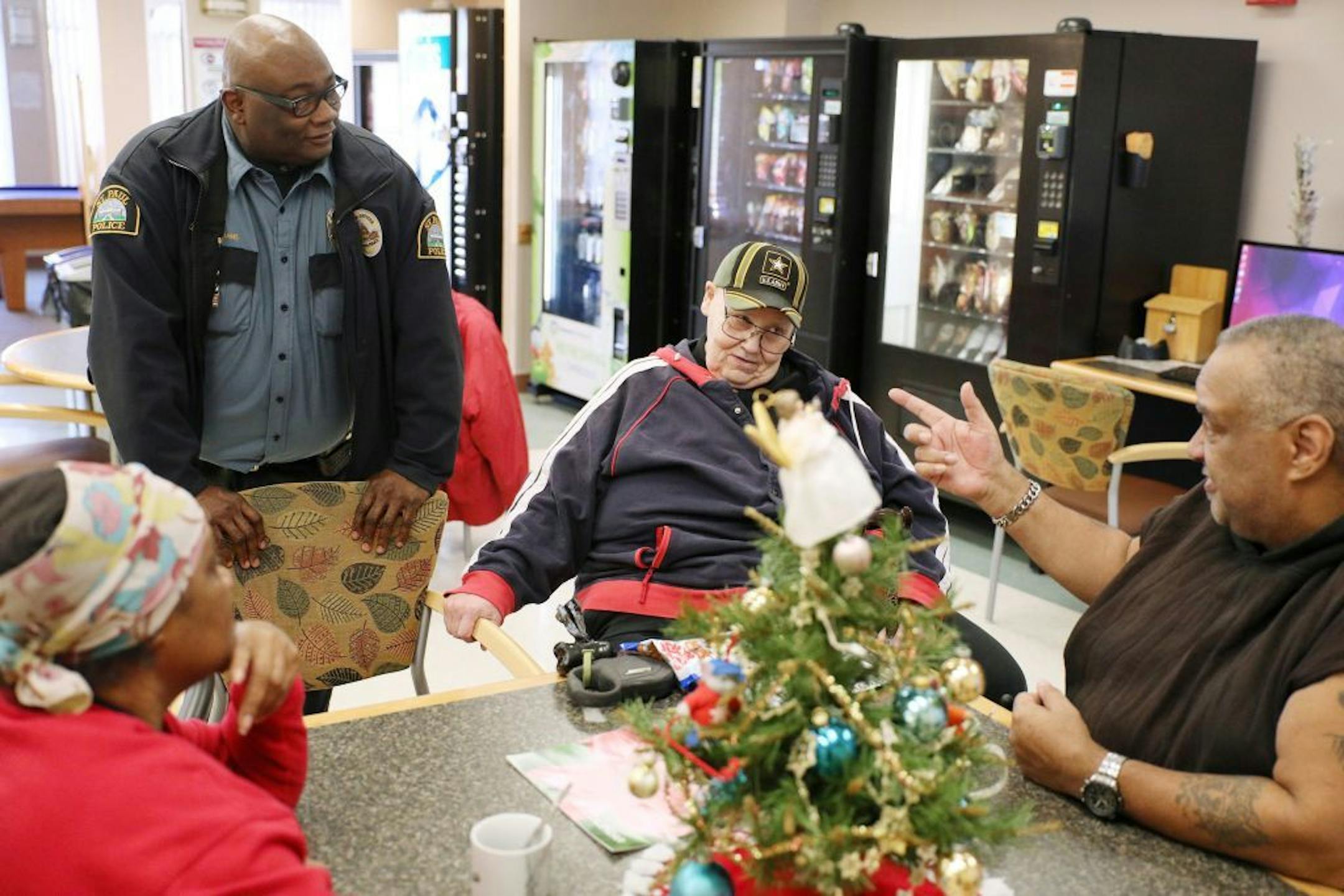 St. Paul police officer Greg Williams talked with a group of residents including Craig Schusbel, center, during breakfast.
