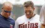 After getting a single against the Kansas City Royals, Minnesota Twins' Robbie Grossman, right, leaves the field with trainer Tony Leo in the seventh 