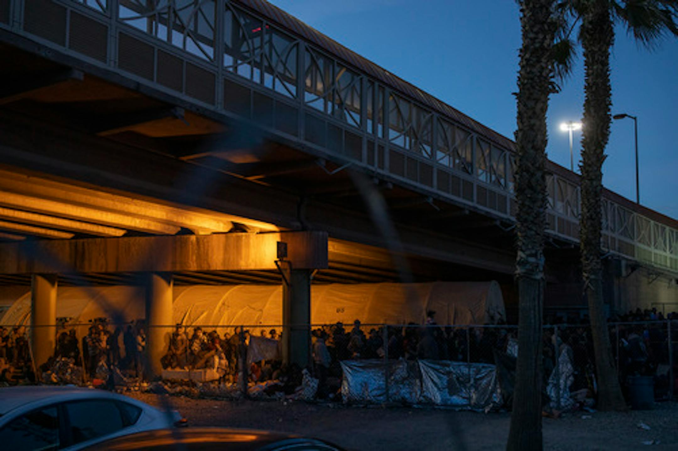 FILE -- Migrants are temporarily held by Customs and Border Protection in an enclosed area beneath the Paso del Norte International Bridge in El Paso, Texas, March 29, 2019. The crunch in space for processing migrants at the southern border is spreading to ICE detention centers across the country, which are now scrambling to expand. The White House is asking for $4.5 billion in emergency border funding.