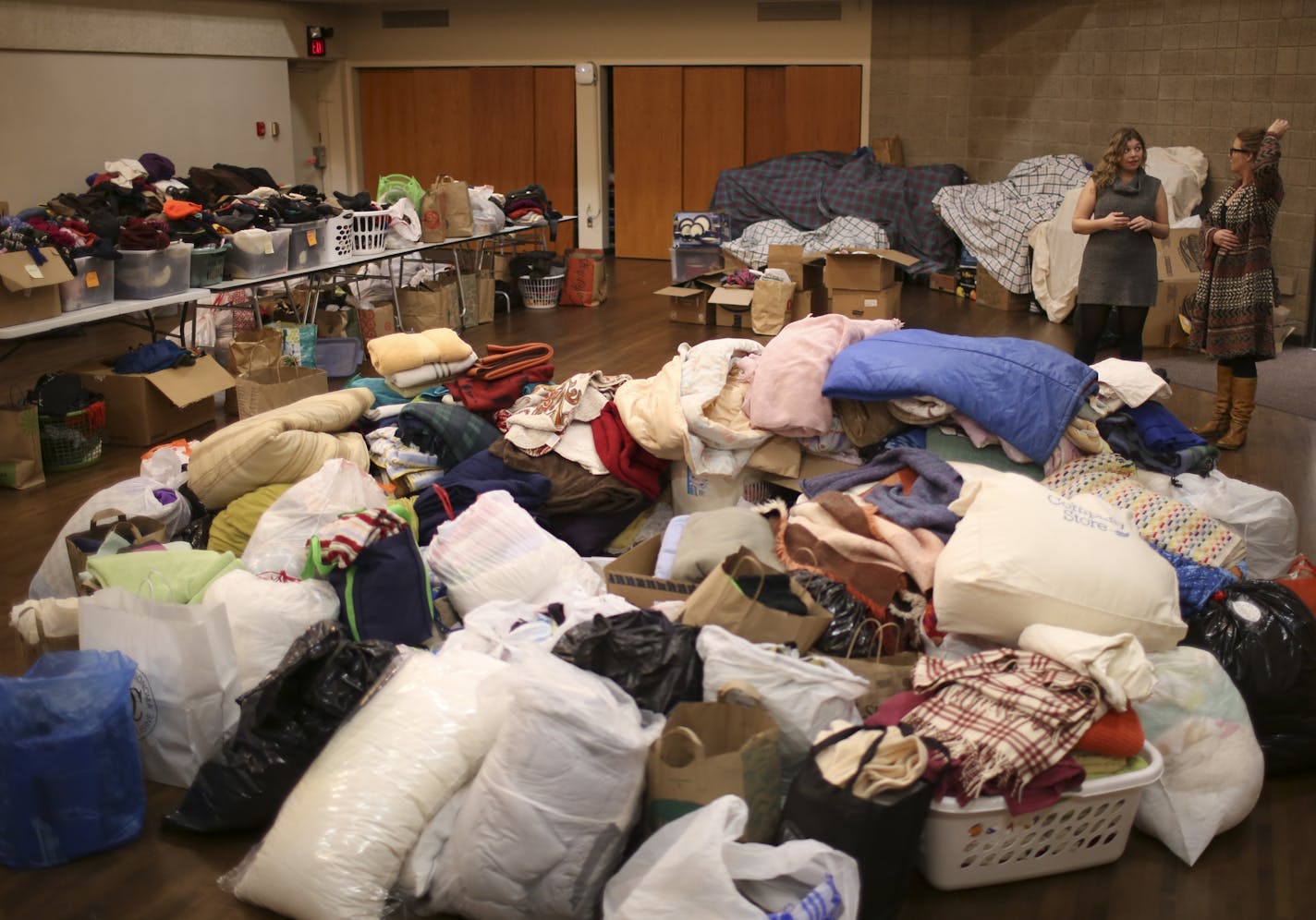 International Institute of Minnesota staffers Bridget Ehrman-Solberg and Kenzie Kutscheid, right, discussed how to tackle the sorting of the huge number of donations the organization took in over the past couple of days. ] JEFF WHEELER &#xef; jeff.wheeler@startribune.com An outpouring of donations from individuals eager to help have been pouring in to the International Institute of Minnesota in St. Paul continuously this week. Much of outpouring is in direct response to statements by some electe