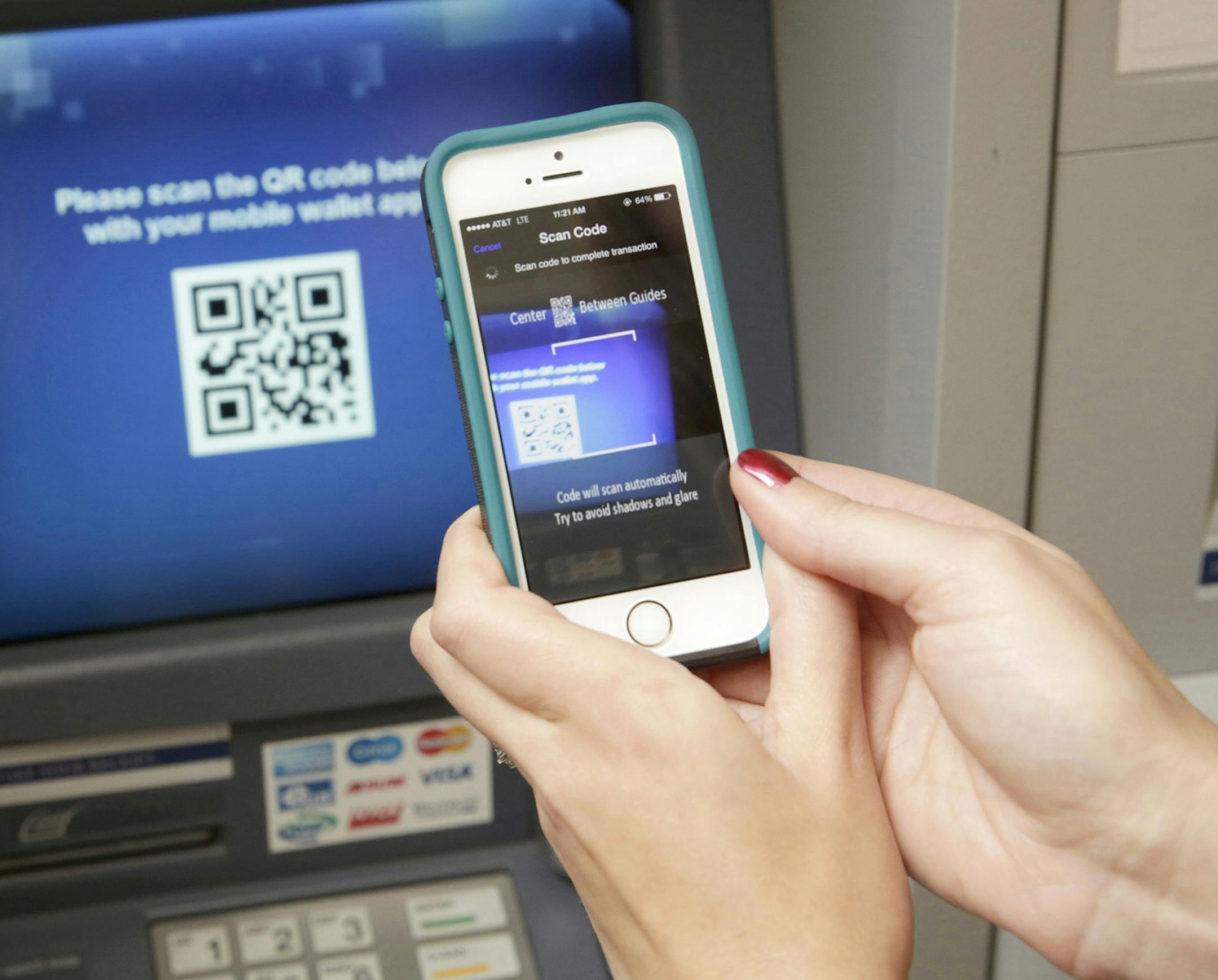 Kirsten Keary-Taylor, Retail Product Specialist at WinTrust Financial, demonstrates the use of WinTrust bank's cardless ATM machine Monday Dec. 8, 2014 at the downtown Chicago branch. The machine uses a QR code and your smartphone's QR scanner to communicate the transaction. (Michael Tercha/Chicago Tribune/TNS) ORG XMIT: 1162263