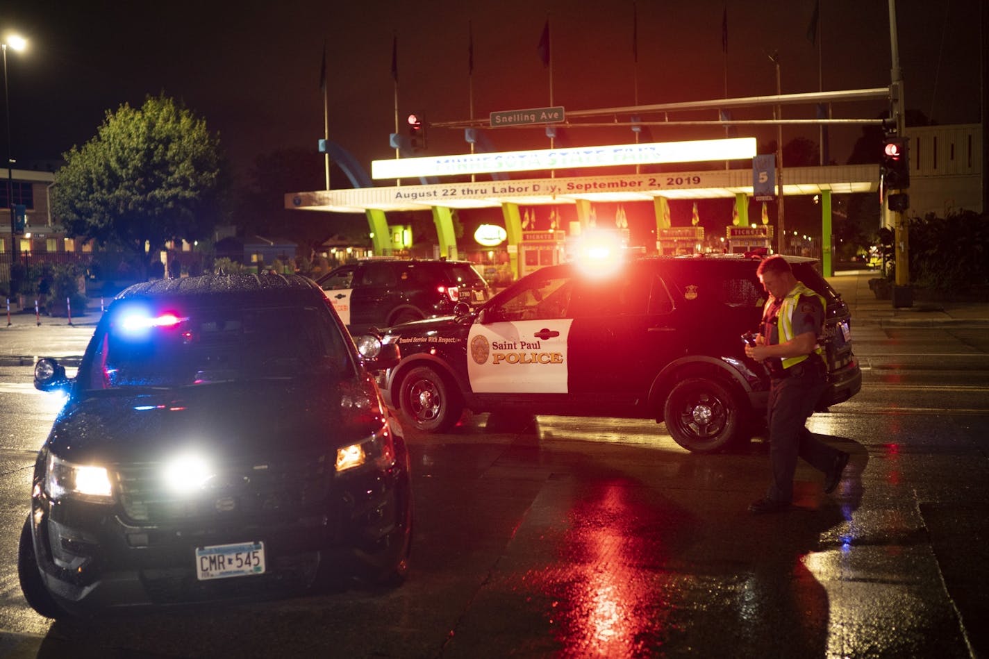 Police vehicles remained at the intersection of Midway Parkway and Snelling Ave. near the main entrance to the Minnesota State Fair grounds late Monday night after a shooting and a person reportedly was hit by a car near the same location.