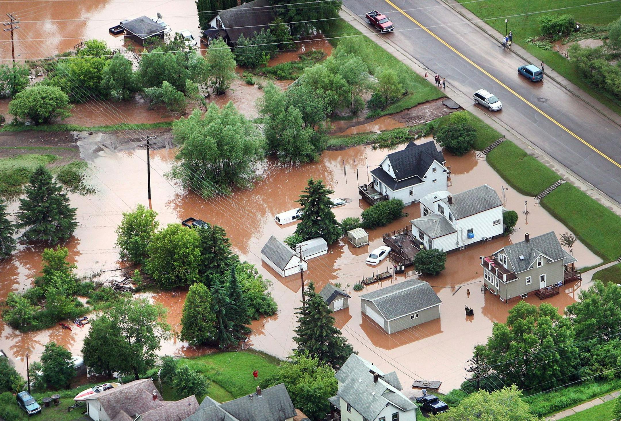 In this aerial photo, waters from an overflowing nearby creek inundate homes in the Irving Park neighborhood of Duluth, Minn., Wednesday afternoon, June 20, 2012. Residents evacuated their homes and animals escaped from pens at a zoo as floods fed by a steady torrential downpour struck northeastern Minnesota, inundating the city of Duluth, officials said Wednesday. (AP Photo/The Duluth News-Tribune, Bob King) ORG XMIT: MIN2012120311082451