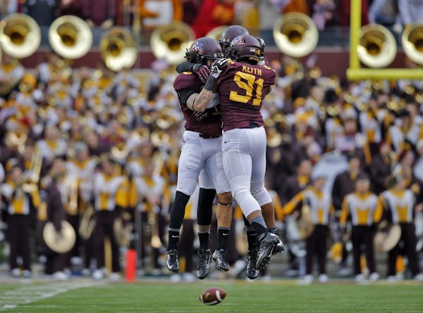 Minnesota defensive players Alex Keith (91), Derrick Wells and Thieren Cockran celebrated in front of the Minnesota band after stopping Penn State on 