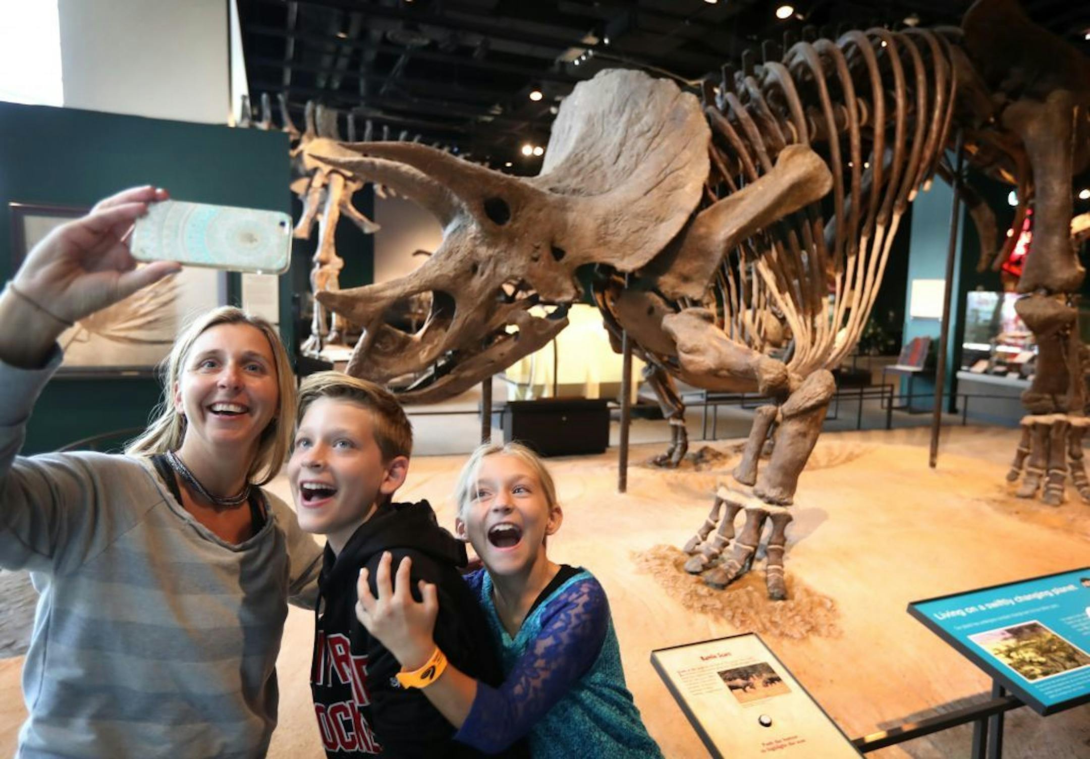Michelle Shirley of Eden Prairie and her children William, 12 and Ava, 9, take a selfie with triceratops at the Science Museum of Minnesota Tuesday afternoon.