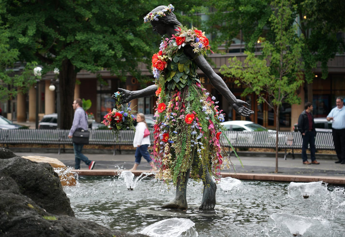 A remade version of St. Paul's historic Rice Park was unveiled at a ceremony Tuesday afternoon. The new park modifications include a more open design with entry corners with seat walls, raised garden beds by the St. Paul Garden Club and a central space for events and gatherings. Here, the girl in the fountain remains and was decked out in flowers Tuesday afternoon.]
brian.peterson@startribune.com
St. Paul, MN Tuesday, June 11, 2019