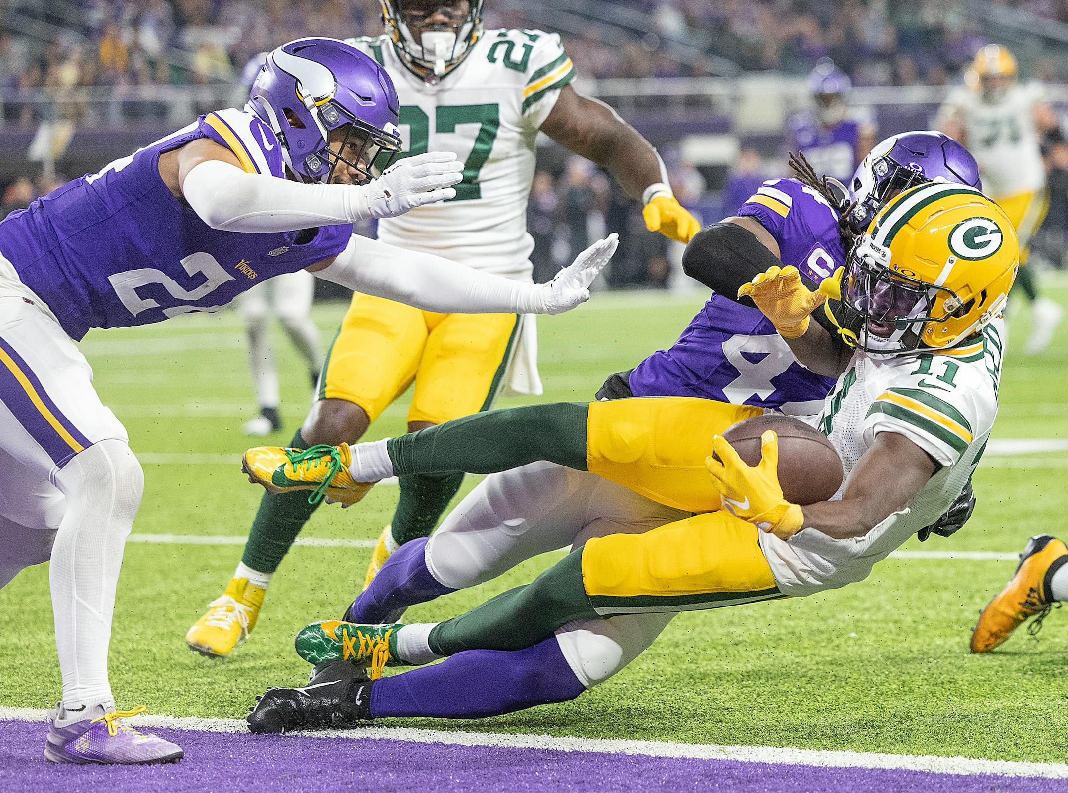 Packers wide receiver Jayden Reed (11) reaches into the end zone for a touchdown defended by Vikings safety Josh Metellus (44) in the second quarter at U.S. Bank Stadium, in Minneapolis, Minn., on Sunday, Dec. 31, 2023. ] Elizabeth Flores • liz.flores@startribune.com